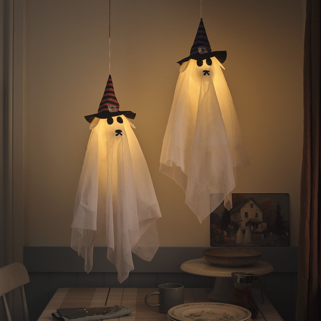 Un lot de deux chiens fantomes déguisés en sorcières suspendus au dessus de la table à manger. Une déco d'halloween originale et hors du commun. 