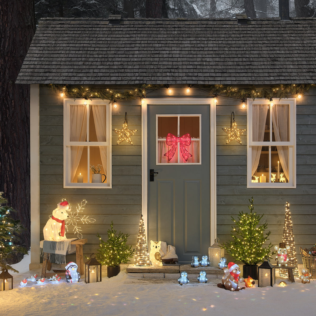 Une scène de maison de vacances illuminée avec fenêtres décorées, sapin de Noël et décoration festive.